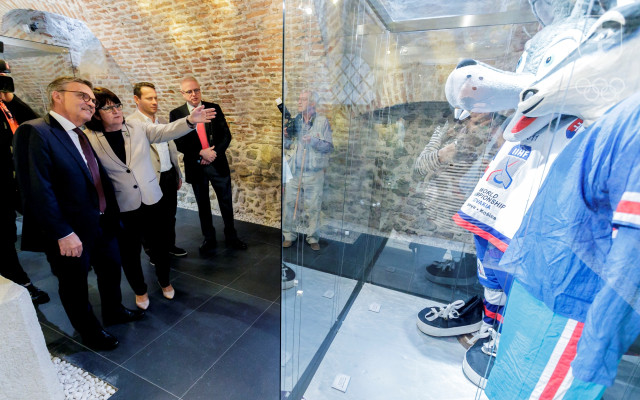 Pred panelom s maskotmi MS zľava prezident IIHF René Fasel, riaditeľka SOŠV – SOŠM Zdenka Letenayová, prezident SZĽH Martin Kohút a generálny sekretár IIHF Horst Lichtner počas otvorenia výstavy „Opäť žijeme hokejom!“.