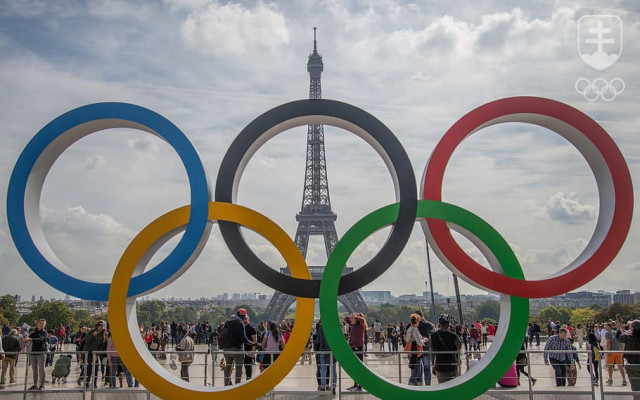 Veľké olympijské kruhy pred dominantou Paríža - Eiffelovou vežou.