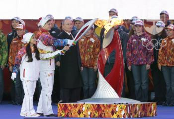 Momentka zo zapálenia olympijského ohňa na Červenon námestí v Moskve. Oheň zapálil ruský prezident Vladimir Putin a dvojica mladých športovcov. FOTO: TASR/AP