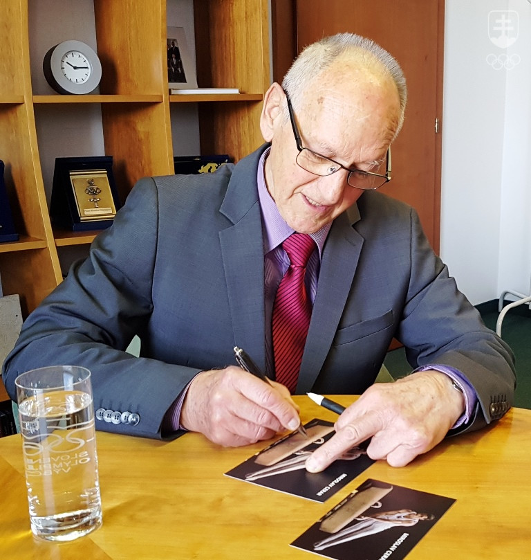 Miroslav Cerar pri podpise autogramových kartičiek s fotografiou z čias najväčšej gymnastickej slávy. FOTO: ĽUBOMÍR SOUČEK