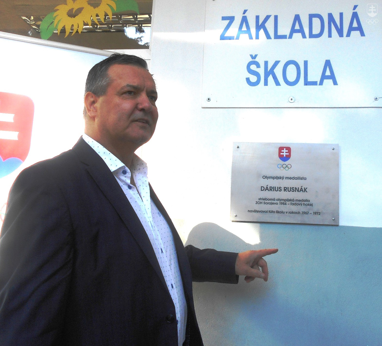Strieborný hokejista zo ZOH 1984 Dárius Rusnák pred svojou pamätnou tabuľou na ZŠ Golianova v Banskej Bystrici.