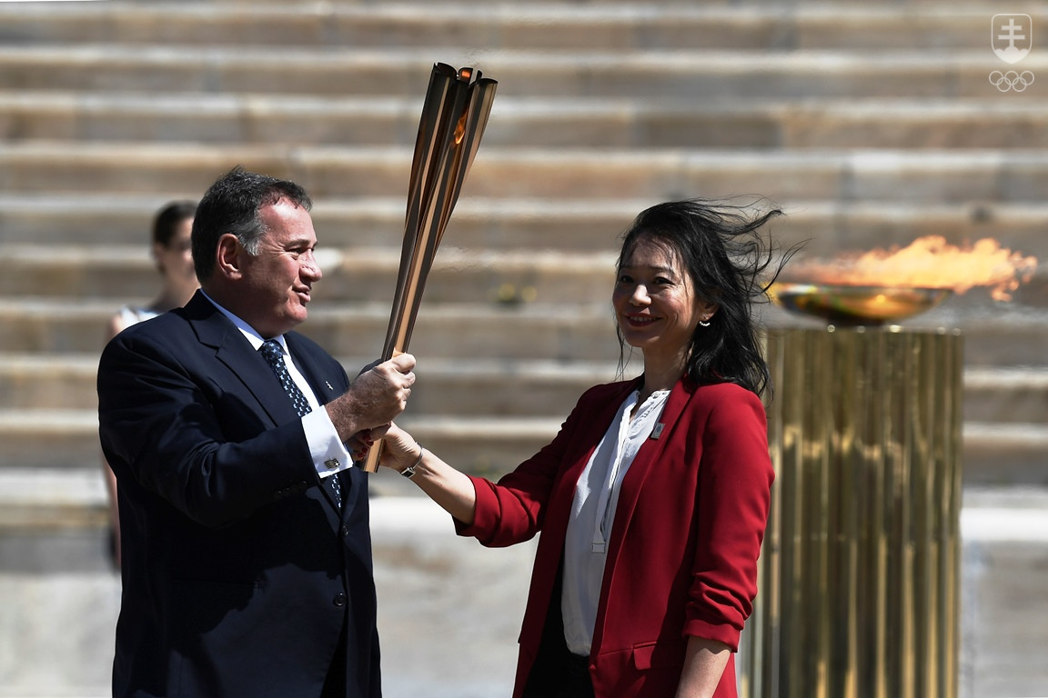 Prezident Gréckeho olympijského výboru Spyros Capralos odovzdal pochodeň s olympijským ohňom japonskej olympioničke v plávaní Naoko Imotovej.