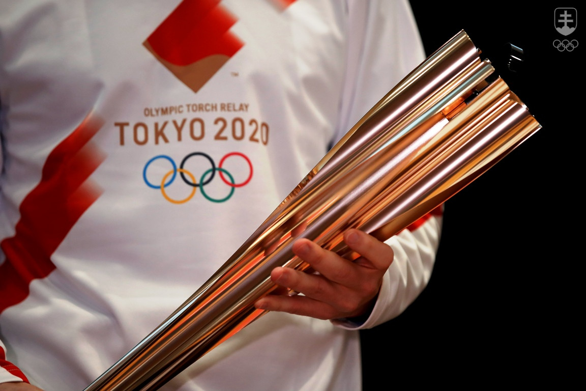 Olympijská pochodeň pre Tokio 2020 v rukách bežca v tričku s dizajnom štafety.