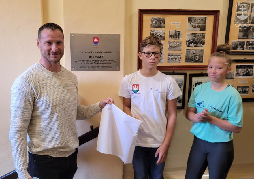 Erikovi Vlčekovi pri odhalení jeho novej pamätnej tabule na ZŠ Pohraničná v Komárne asistovali dvaja žiaci školy.
