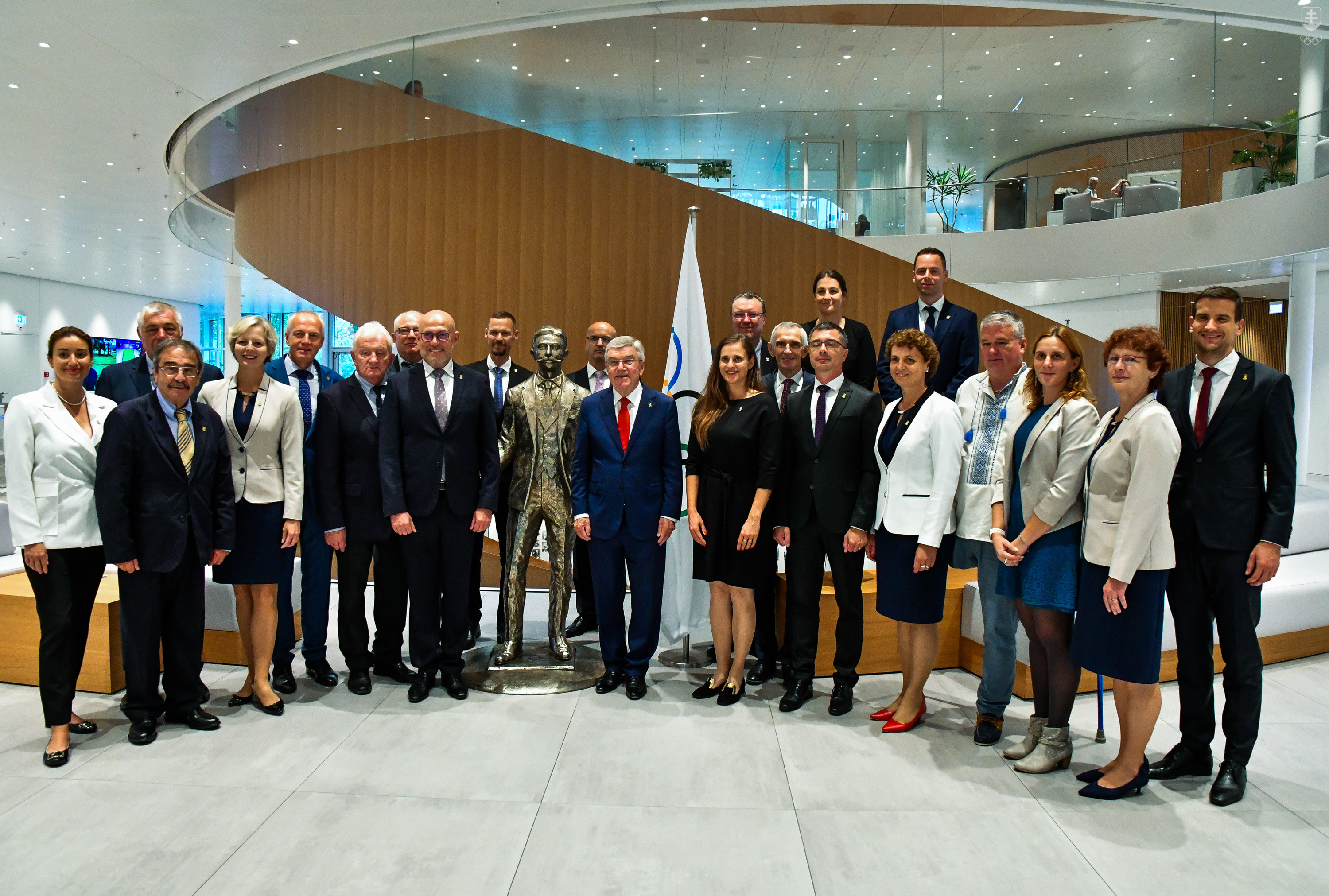 Delegácia SOŠV spoločne s prezidentom MOV Thomasom Bachom pri soche Pierra de Coubertin vo foyeri Olympijského domu v Lausanne.